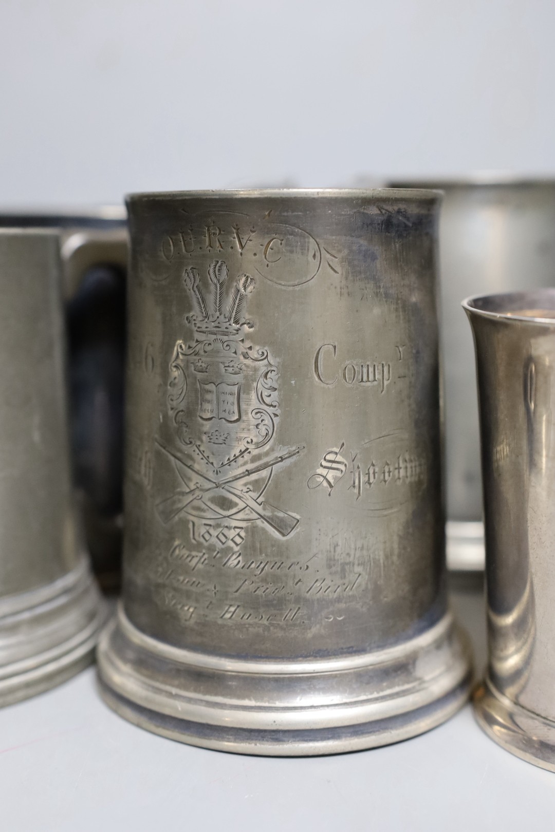 An Edwardian silver Kings company 204th prize Bisley 1904 commemorative beaker, 10cm and a collection of various pewter and plated shooting trophy mugs and tankards, Silver beaker 10 cms high.